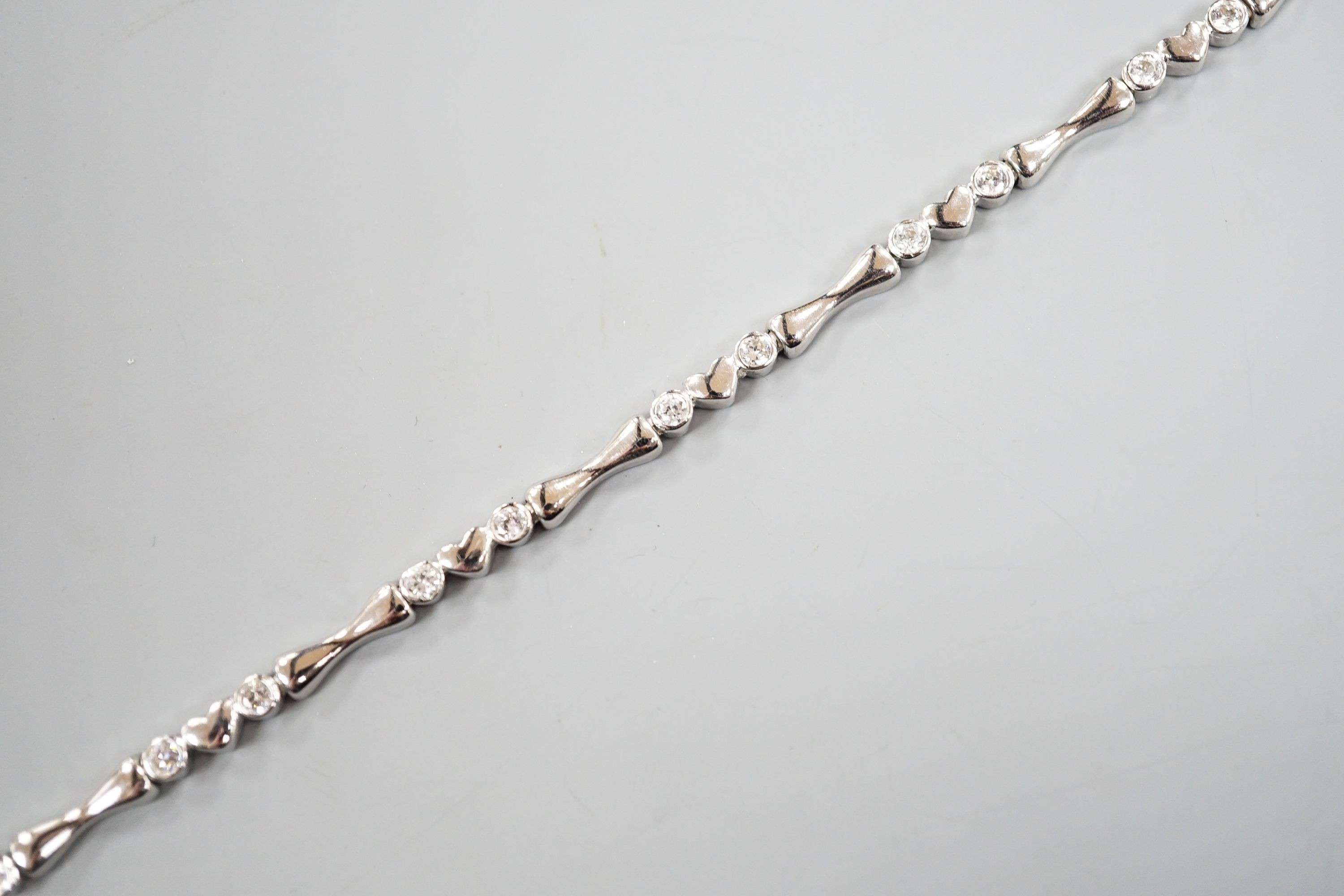 A modern 750 white metal and sixteen stone diamond set line bracelet, 19.2cm, gross weight 12.9 grams.